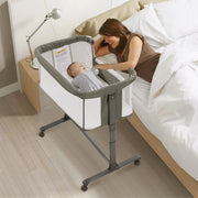 Woman with a baby in a bedside crib in a bedroom setting
