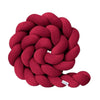 Red braided pillow on a white background