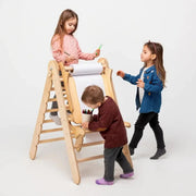 Children playing with a wooden climbing toy on a white background