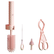 Set of pink cleaning tools including a brush, scissors, and other utensils on a white background.